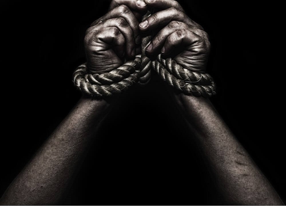 Two hands with the bonds of slavery.