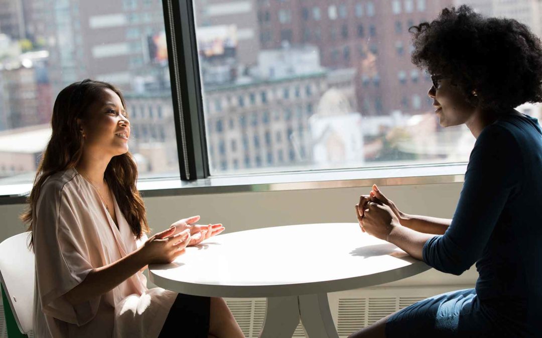 A person standing on a table

two women sharing a conversation at a table